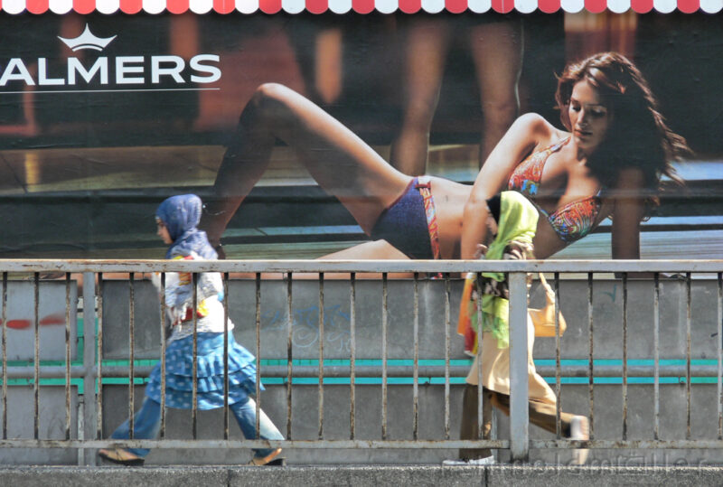 Palmers Reklamewand mit vorbeilaufenden Frauen